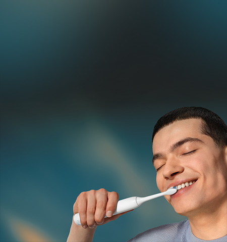 Grafika przedstawiająca zbliżenie na twarz mężczyzny myjącego zęby szczoteczką soniczną.