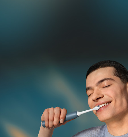 Grafika przedstawiająca zbliżenie na twarz mężczyzny myjącego zęby szczoteczką soniczną.