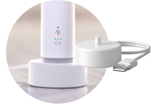 Szczoteczka umieszczona w podstawce ładującej. Obok znajduje się podstawka ładująca.