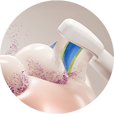 Zbliżenie na szczoteczkę usuwającą z zębów rozbitą płytkę.