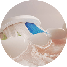 Zbliżenie na szczoteczkę czyszczącą zęby i wytwarzającą mikrobąbelki.