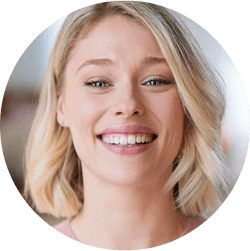 Kobieta uśmiecha się, ukazując zęby.