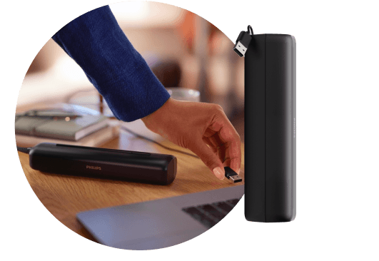 Dłoń podpinająca etui podróżne do laptopa za pomocą kabla USB. Obok znajduje się etui podróżne.