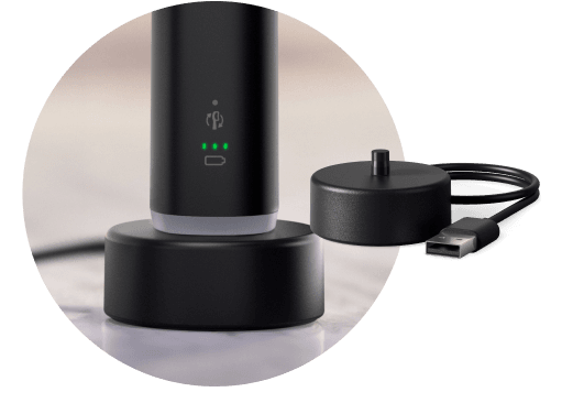 Szczoteczka umieszczona w podstawce ładującej. Obok znajduje się podstawka ładująca.