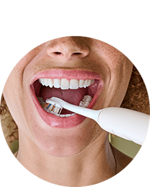 Zbliżenie na usta osoby szczotkującej zęby.