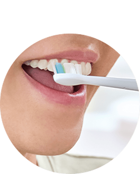 Zbliżenie na usta osoby szczotkującej zęby.